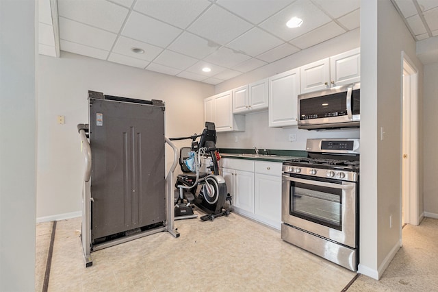 kitchen featuring a paneled ceiling, sink, white cabinets, and appliances with stainless steel finishes