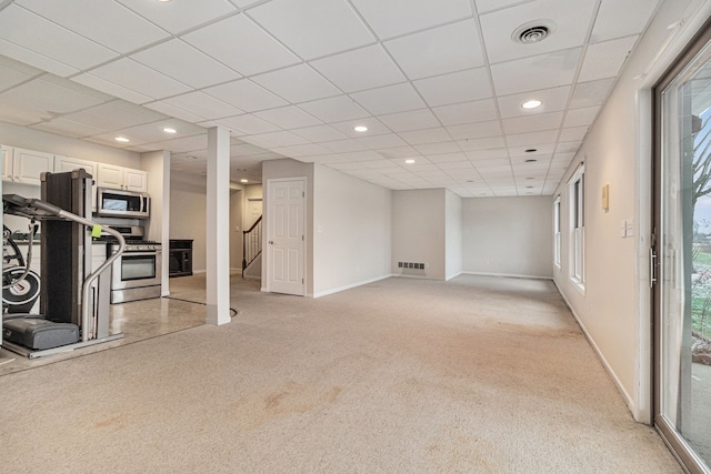 basement featuring light carpet and a drop ceiling