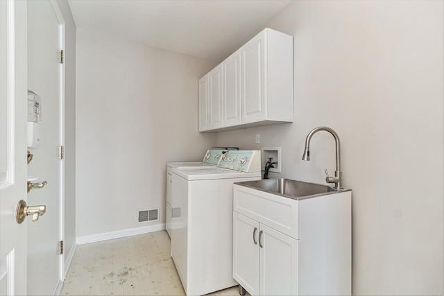 clothes washing area featuring washer and dryer, cabinets, and sink