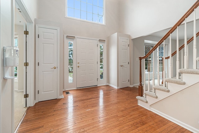 foyer featuring a towering ceiling and light hardwood / wood-style floors