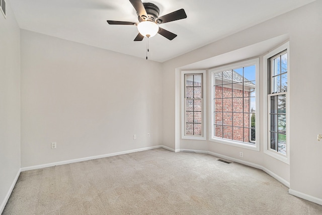 spare room featuring light carpet and ceiling fan