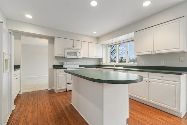 kitchen featuring white cabinets, white appliances, and a kitchen island