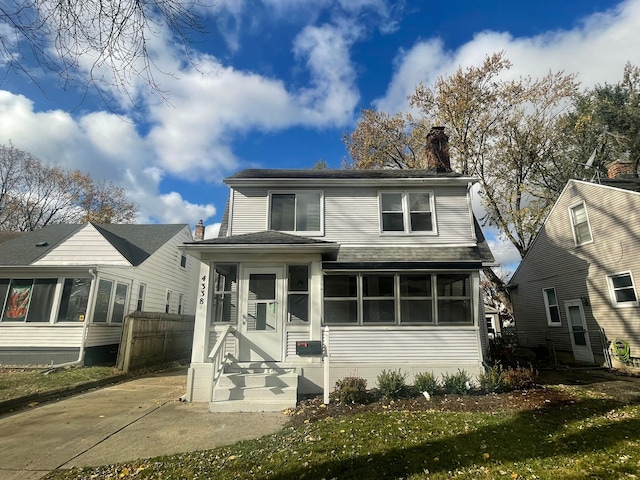 view of front of property with a front yard and a sunroom