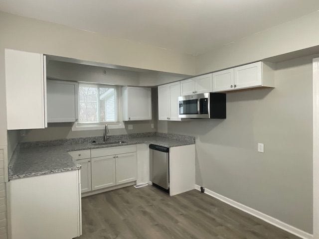 kitchen with sink, white cabinets, stainless steel appliances, and dark hardwood / wood-style floors