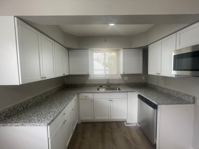 kitchen featuring stone counters, white cabinets, sink, dark hardwood / wood-style floors, and appliances with stainless steel finishes