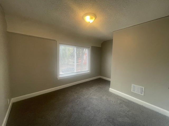 carpeted spare room featuring a textured ceiling