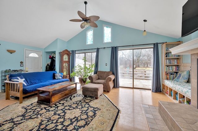 living room featuring ceiling fan, high vaulted ceiling, and light wood-type flooring