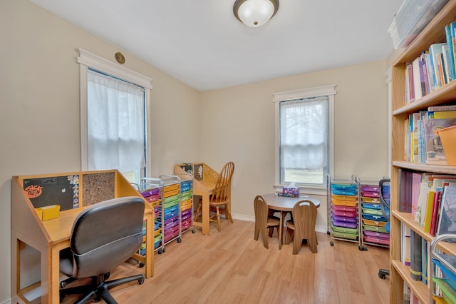 office area with a wealth of natural light and light hardwood / wood-style flooring