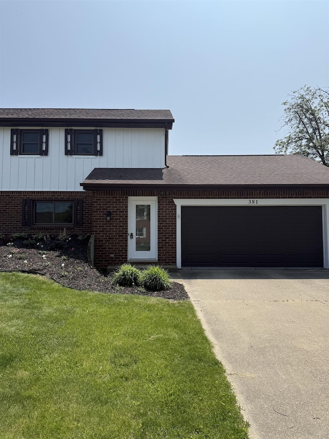 381 Kleiner St, Frankenmuth, MI 48734 - view of front of house with driveway, a garage, a front yard, and brick siding