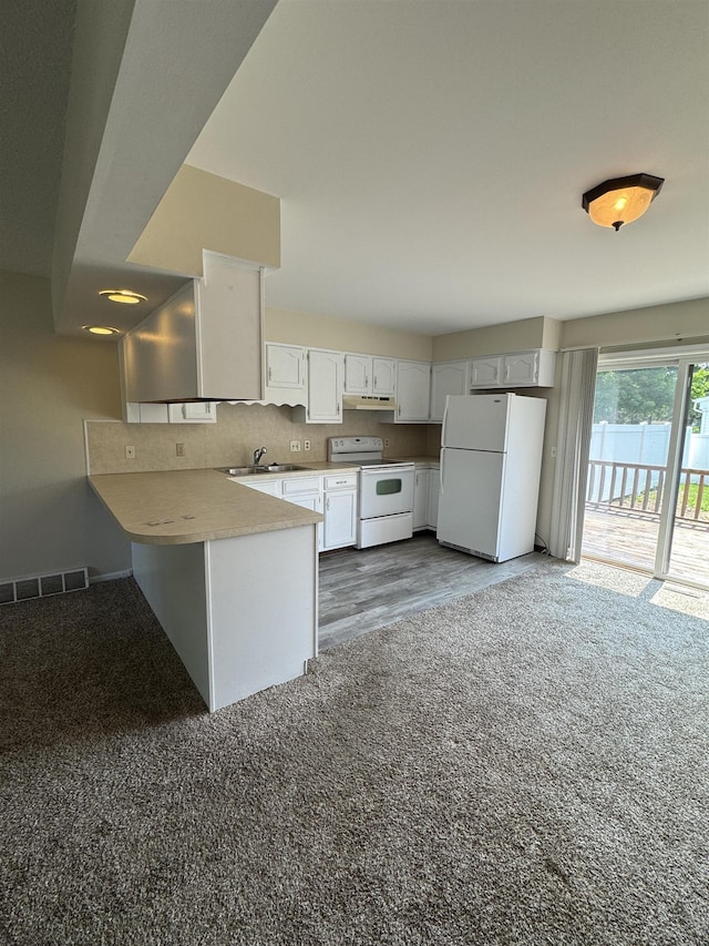 381 Kleiner St, Frankenmuth, MI 48734 - kitchen with white appliances, a peninsula, under cabinet range hood, a sink, and white cabinetry