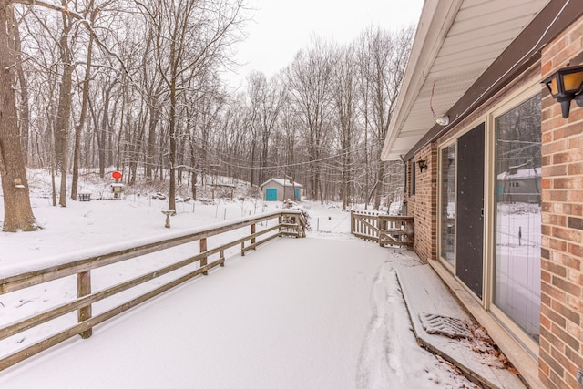 snow covered deck featuring a shed