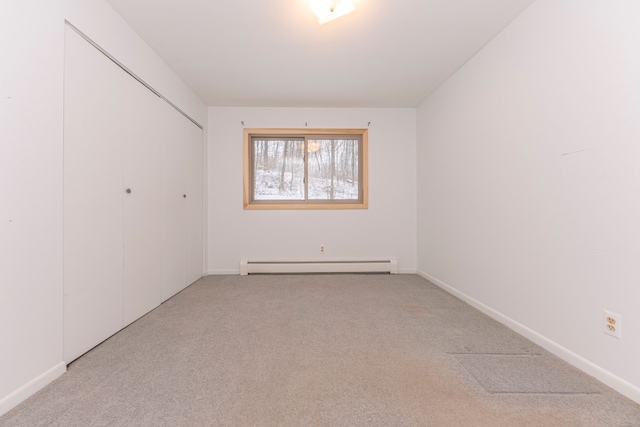 unfurnished room with light colored carpet and a baseboard radiator