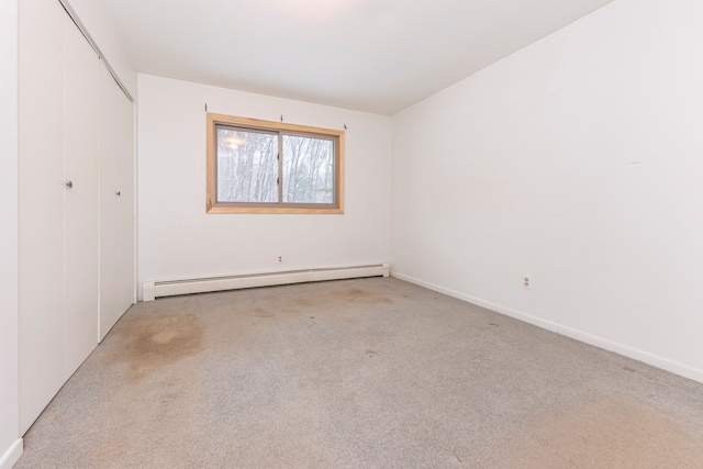 empty room with a baseboard radiator and light colored carpet