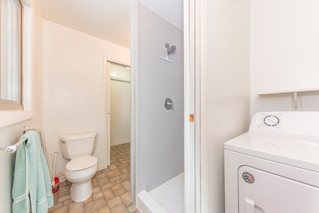 bathroom with washer / clothes dryer and toilet