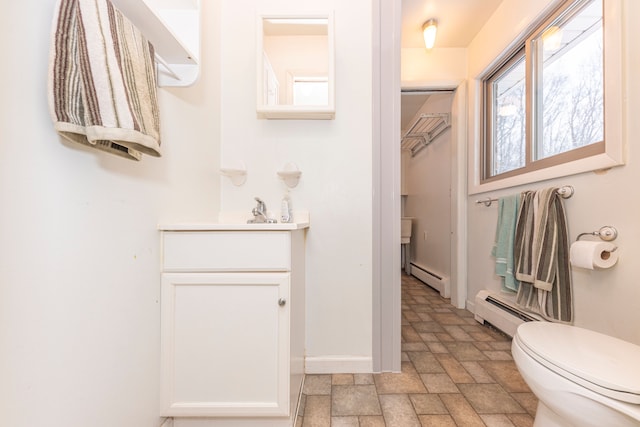 bathroom featuring vanity, toilet, and baseboard heating