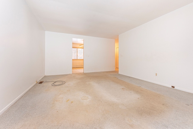 carpeted spare room featuring a baseboard radiator