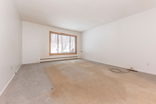 carpeted spare room featuring a baseboard heating unit