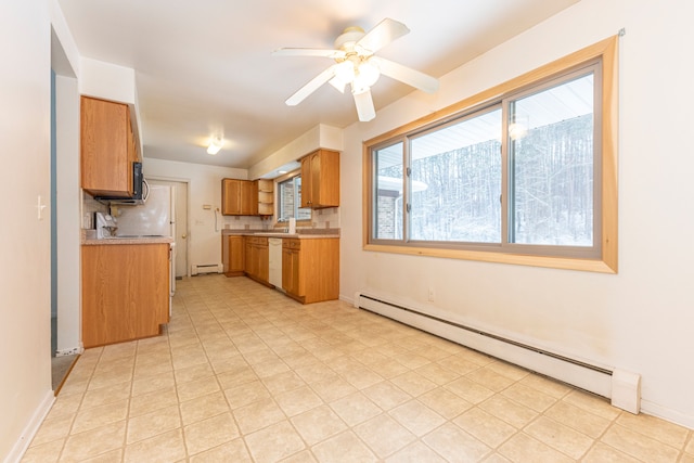 kitchen featuring white dishwasher, sink, decorative backsplash, ceiling fan, and a baseboard radiator