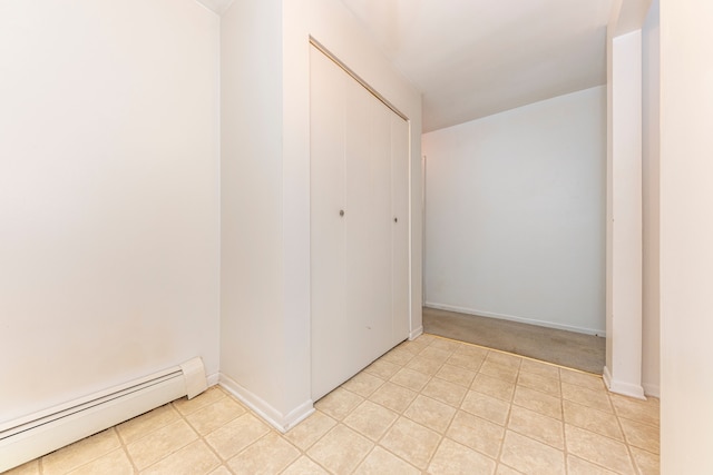 unfurnished bedroom featuring a baseboard radiator and a closet