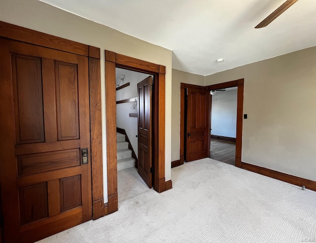 unfurnished bedroom featuring ceiling fan and light carpet