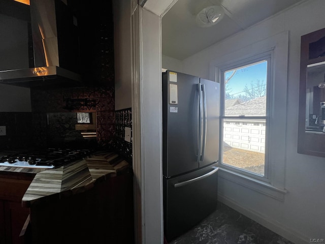 kitchen featuring tasteful backsplash, fridge, and range hood