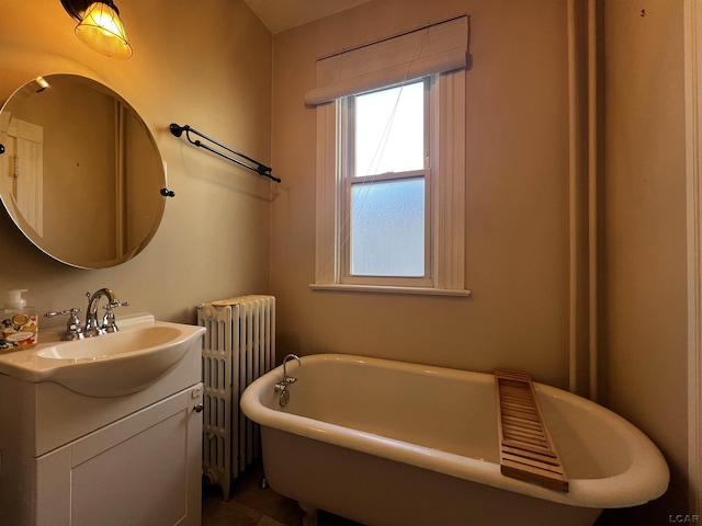 bathroom with radiator, a bathtub, and vanity