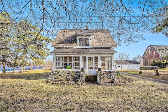 view of front of property featuring a front yard and a sunroom