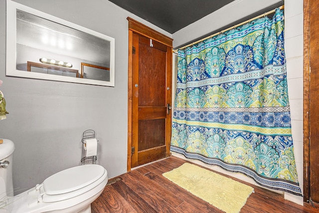 bathroom with walk in shower, hardwood / wood-style floors, and toilet