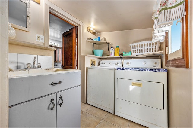 laundry area featuring washer and dryer, light tile patterned floors, and cabinets