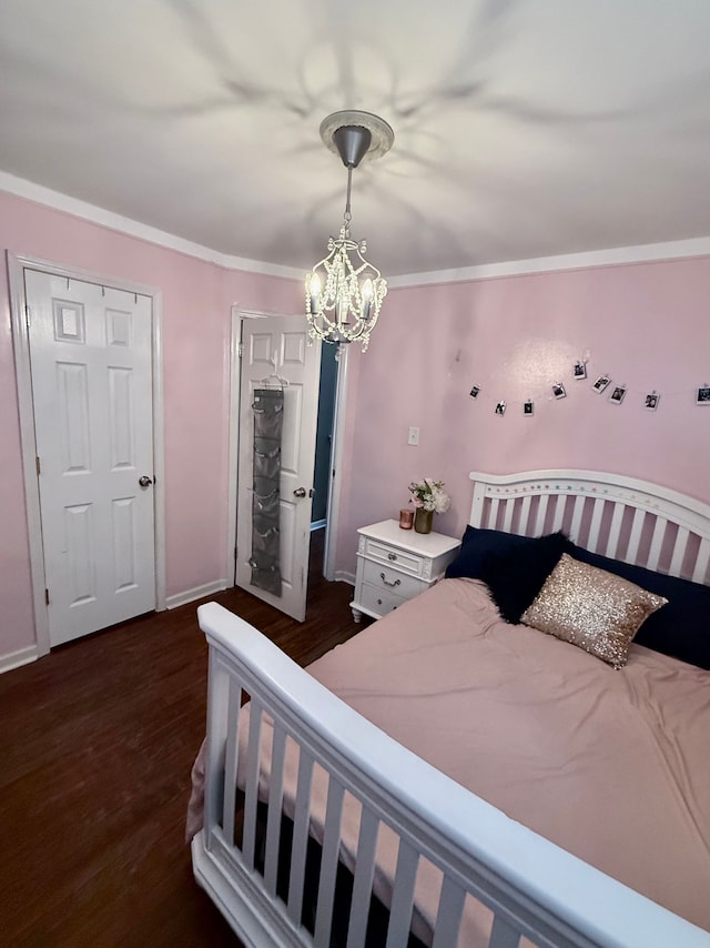 bedroom featuring a chandelier, dark wood-type flooring, and ornamental molding