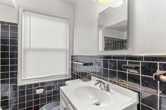 bathroom with vanity and tile walls