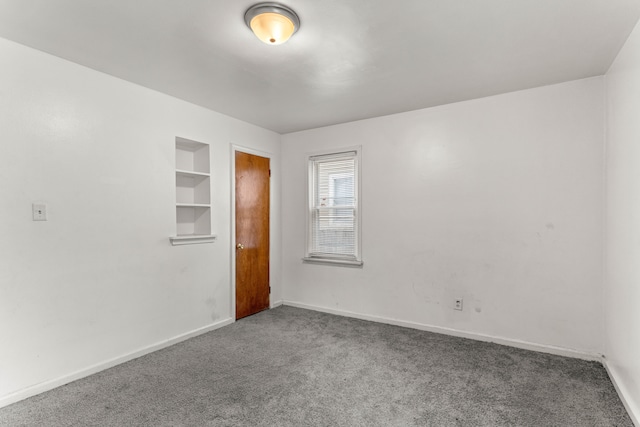 empty room with carpet and built in shelves