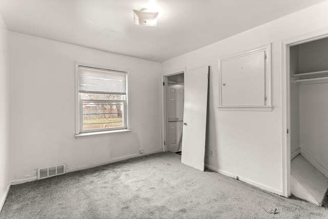 unfurnished bedroom with light carpet and a closet