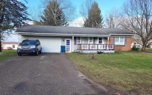 ranch-style home featuring covered porch, a garage, and a front lawn