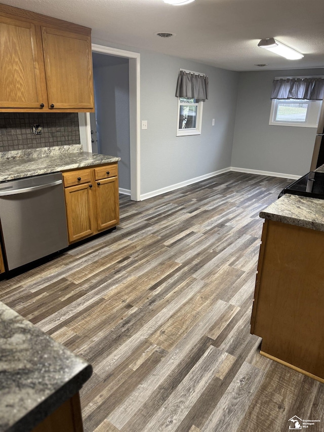 kitchen featuring tasteful backsplash, stainless steel dishwasher, and dark hardwood / wood-style floors