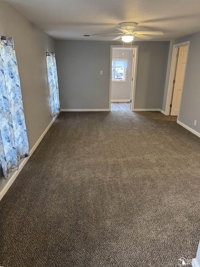 carpeted empty room featuring ceiling fan and a textured ceiling