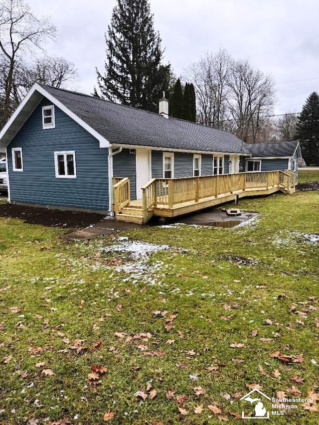 view of front of property with a deck and a front lawn