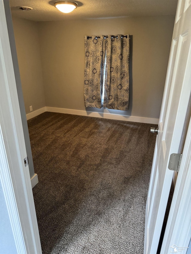 spare room with carpet floors and a textured ceiling