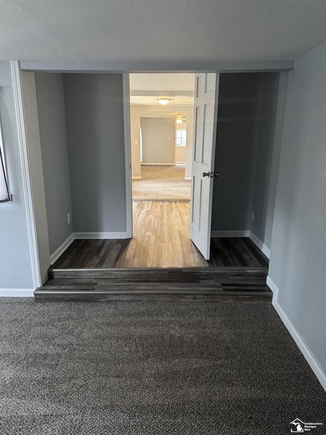 hall featuring dark wood-type flooring and a textured ceiling