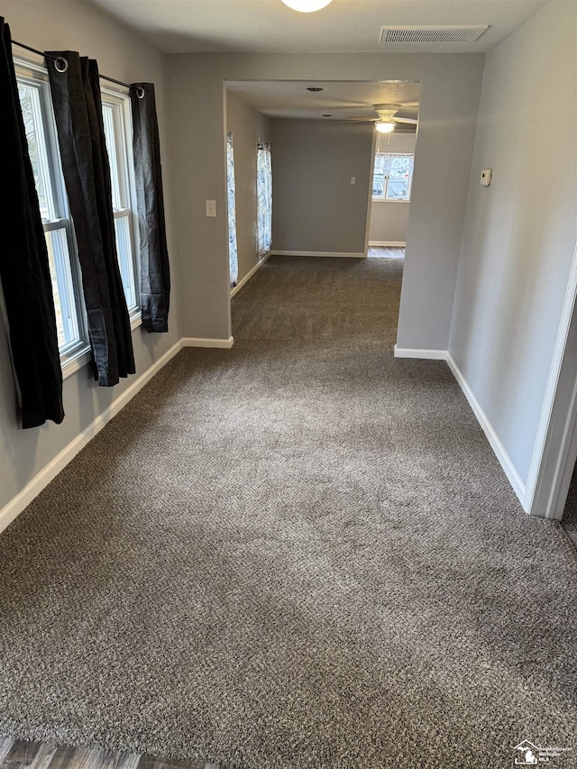 unfurnished room featuring dark colored carpet