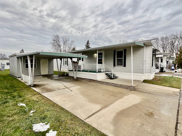 manufactured / mobile home featuring covered porch and a carport