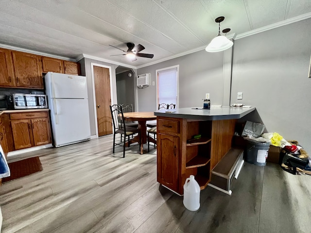 kitchen featuring kitchen peninsula, ornamental molding, ceiling fan, decorative light fixtures, and white fridge