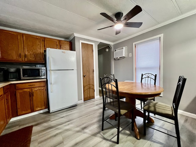 dining space with crown molding, light hardwood / wood-style flooring, ceiling fan, and a wall mounted air conditioner