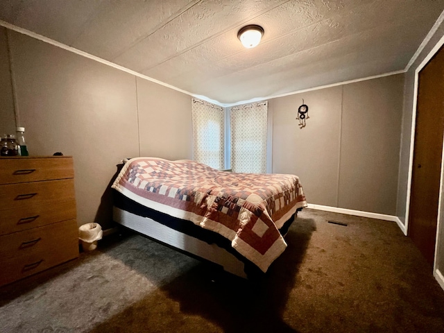 bedroom featuring dark colored carpet, a textured ceiling, and ornamental molding