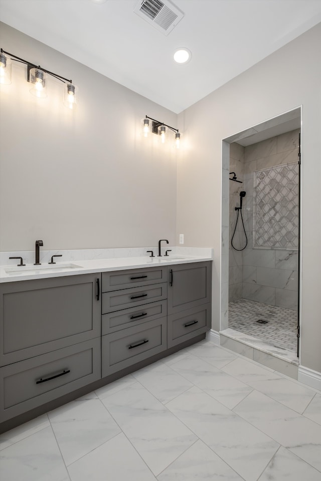 bathroom with tiled shower and vanity