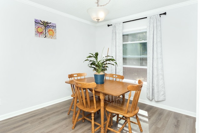 dining area featuring hardwood / wood-style floors, crown molding, and a textured ceiling