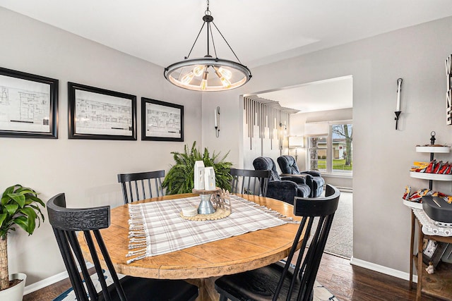 dining area featuring baseboards and dark wood-style flooring