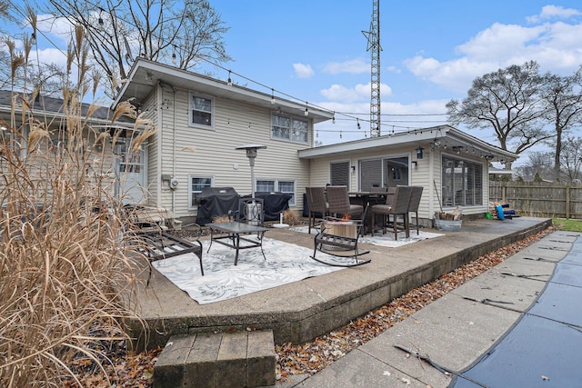 rear view of property with a patio and fence