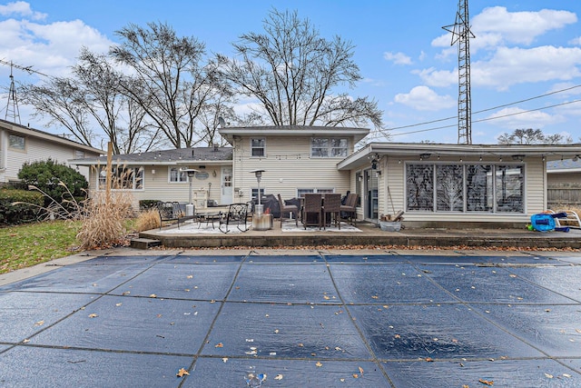 rear view of house featuring a patio area and a covered pool