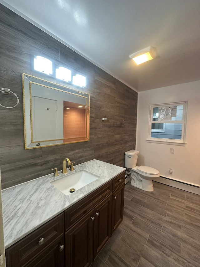 bathroom with vanity, toilet, and baseboard heating